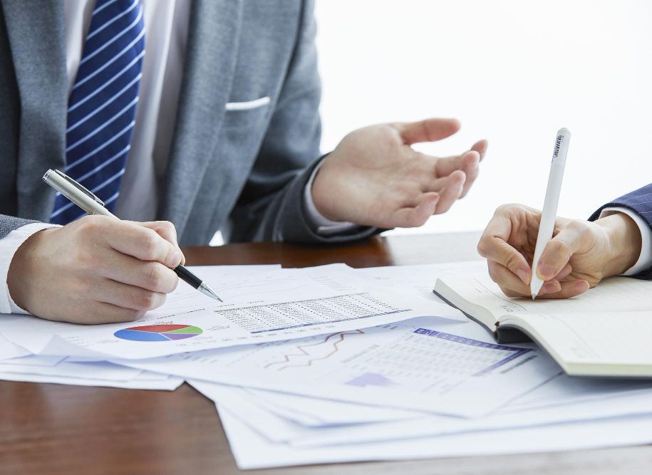 businessmen-elegant-suits-business-meeting-taking-notes-office