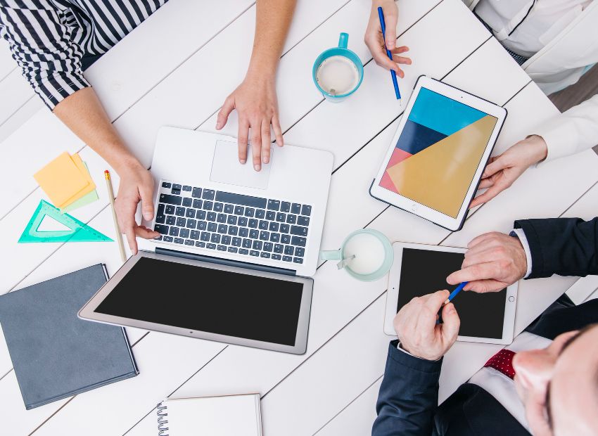 crop-coworkers-using-modern-devices-desk